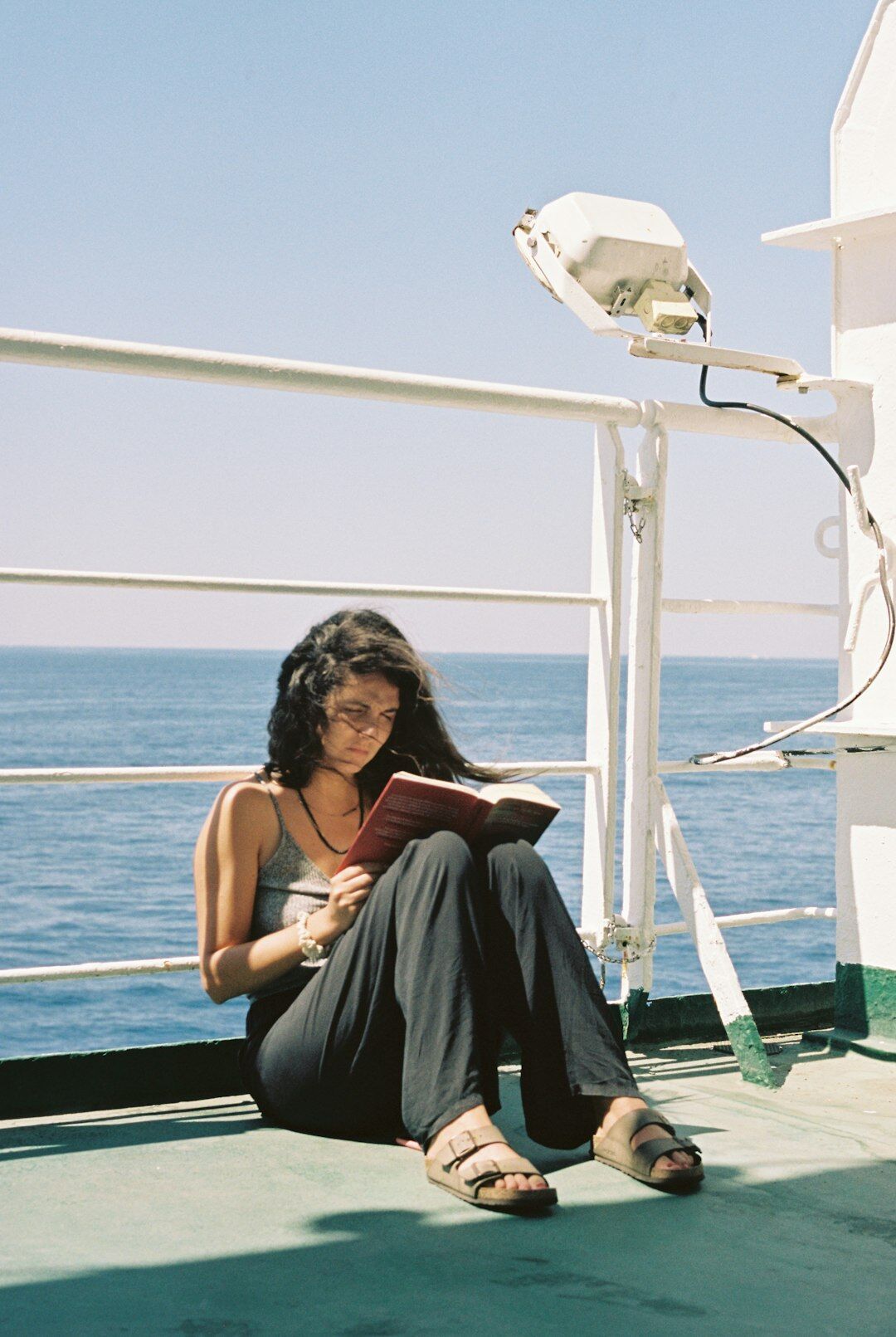 Portrait of a young Argentine woman reading a novel and smiling